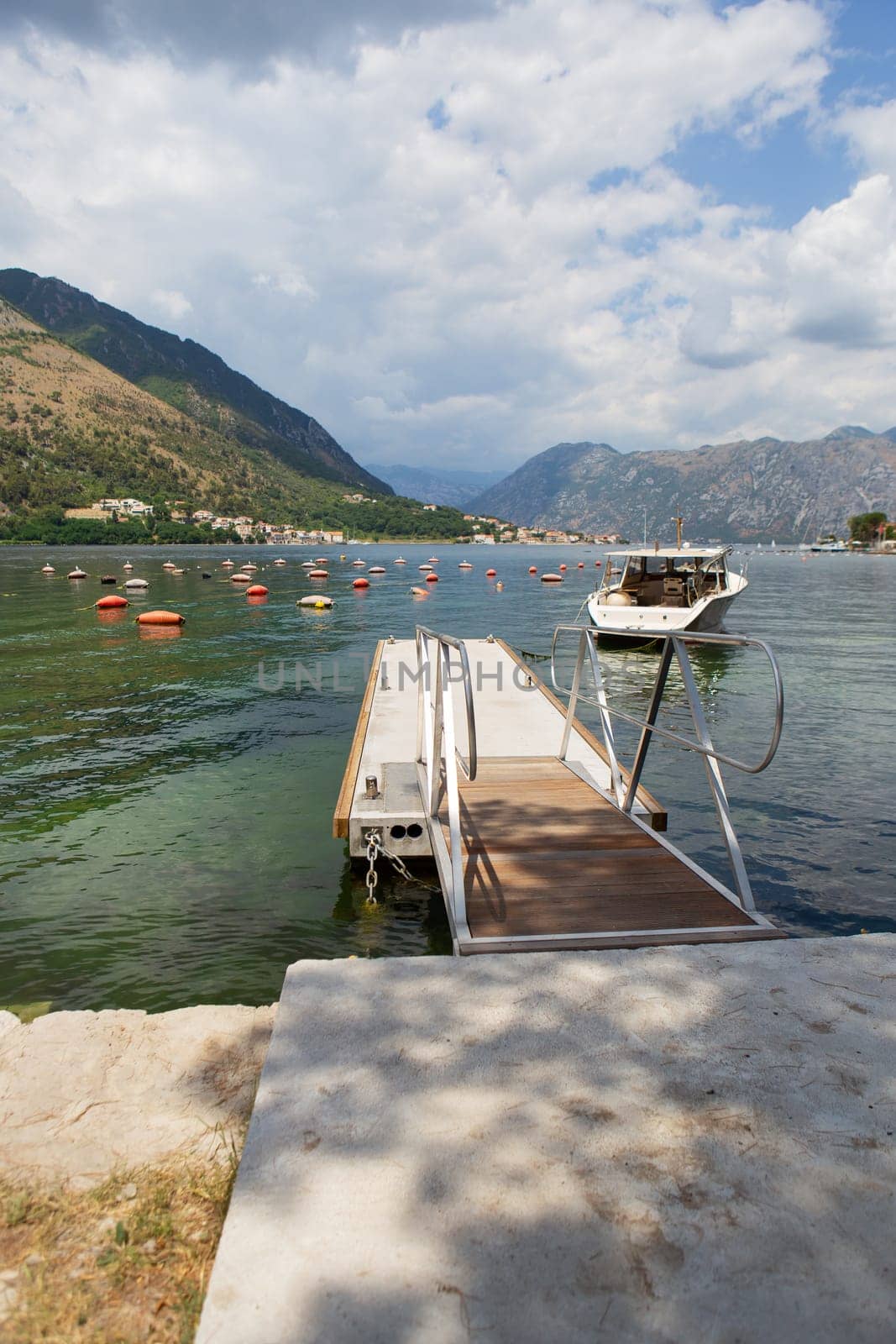 Very beautiful promenade of the Bay of Kotor, a small fishing boat. Montenegro. Beautiful and cozy city, Kotor embankment. The concept of rest and vacation in Europe