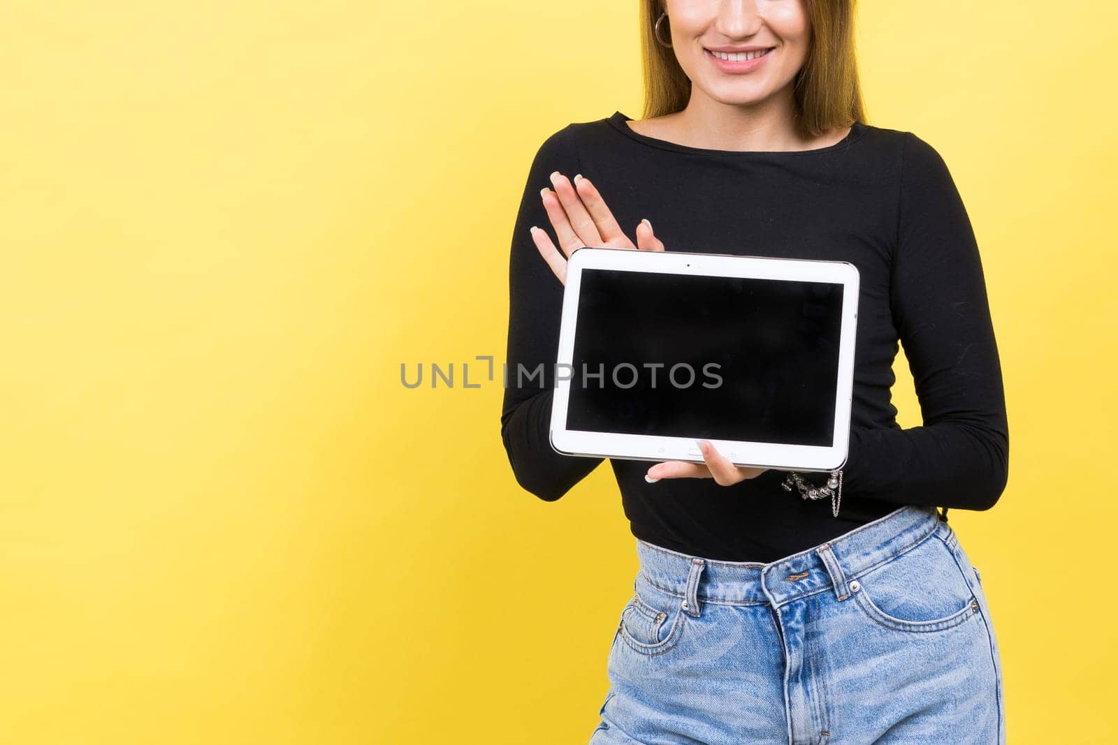 Smart intelligent caucasian young woman student using digital tablet isolated over yellow background by Zelenin