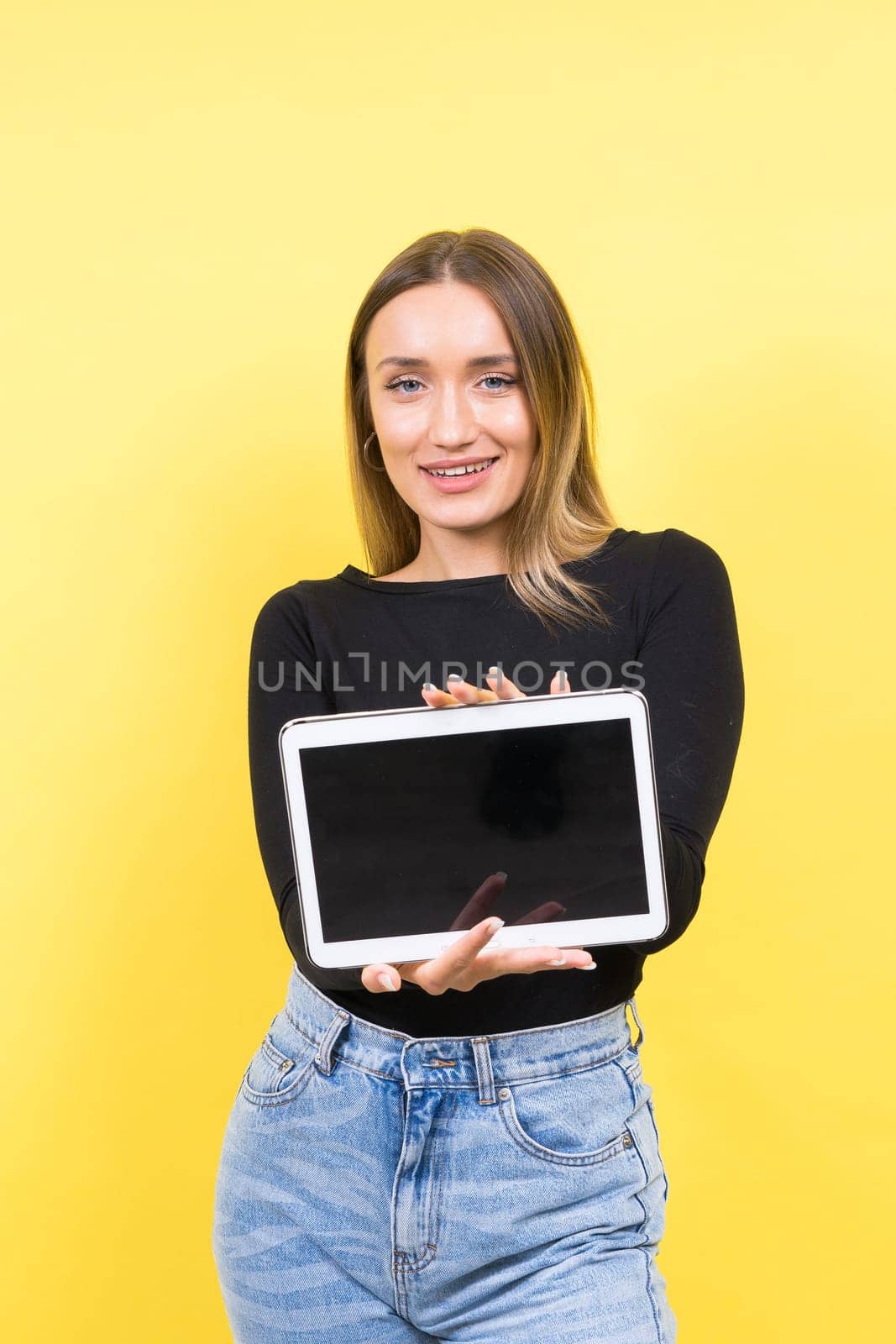 Smart intelligent caucasian young woman student using digital tablet isolated over yellow background by Zelenin