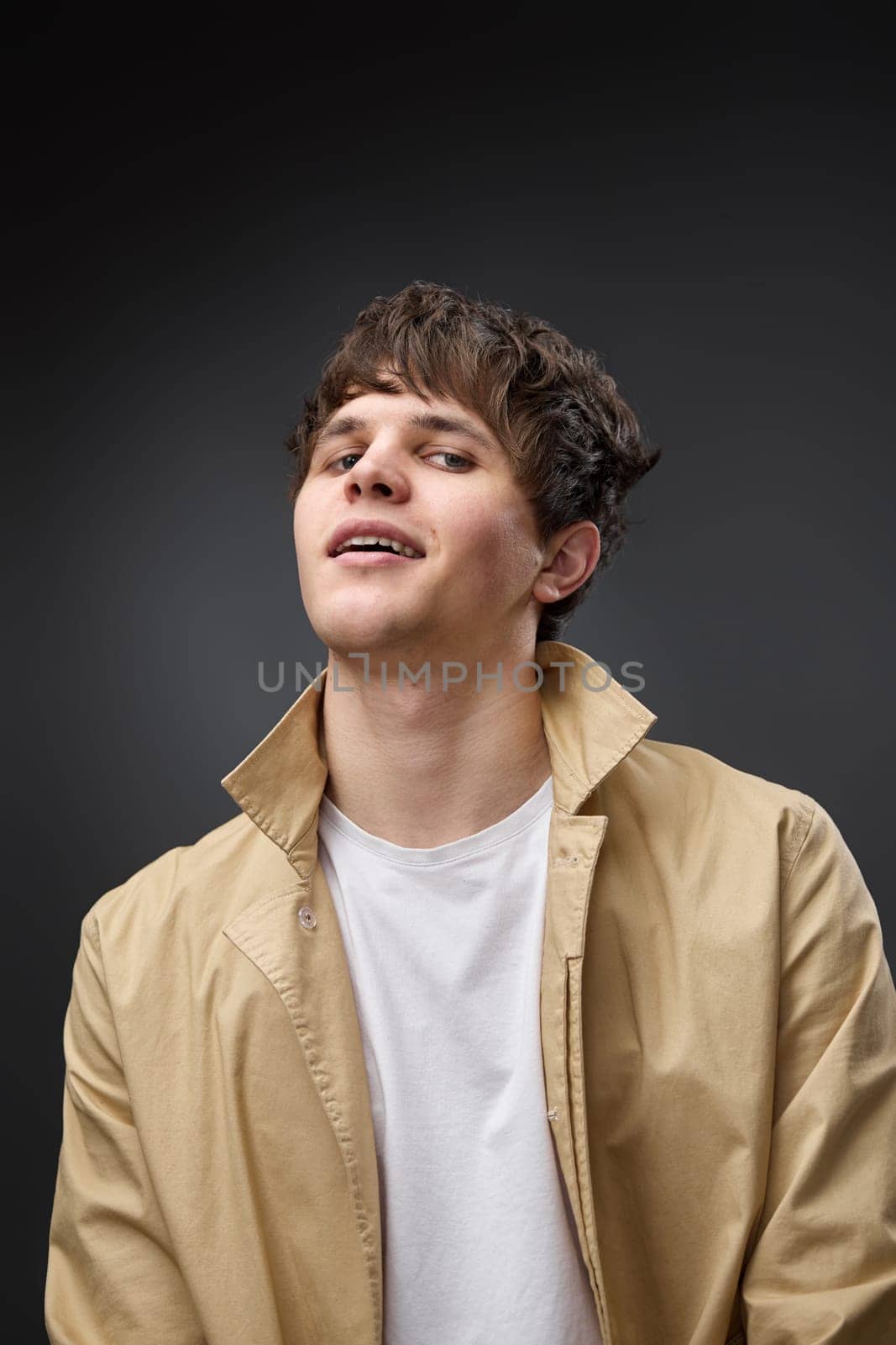 portrait of caucasian man with hairstyle in coat on black background. fashion modern style look