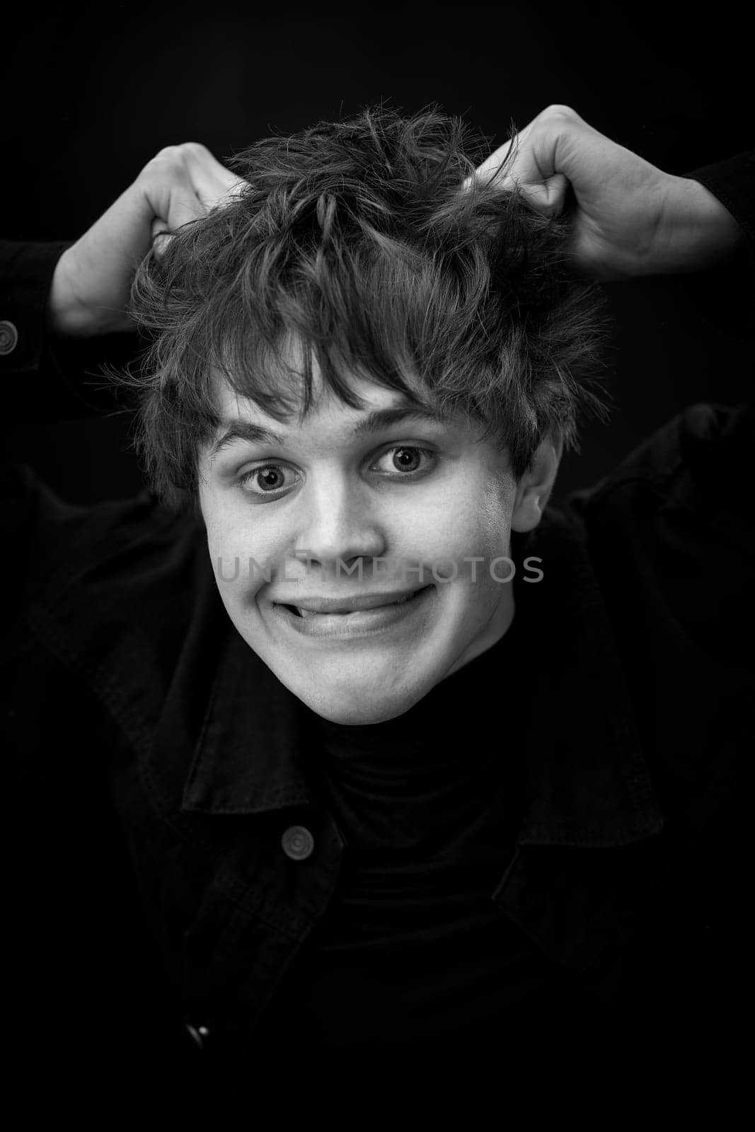portrait of crazy young man with awesome hairdo grimacing . black and white