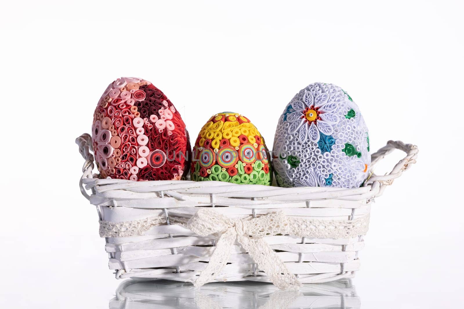 Isolated behind the background a woven basket with three Easter eggs. Important symbols of the world in the Christian religion.