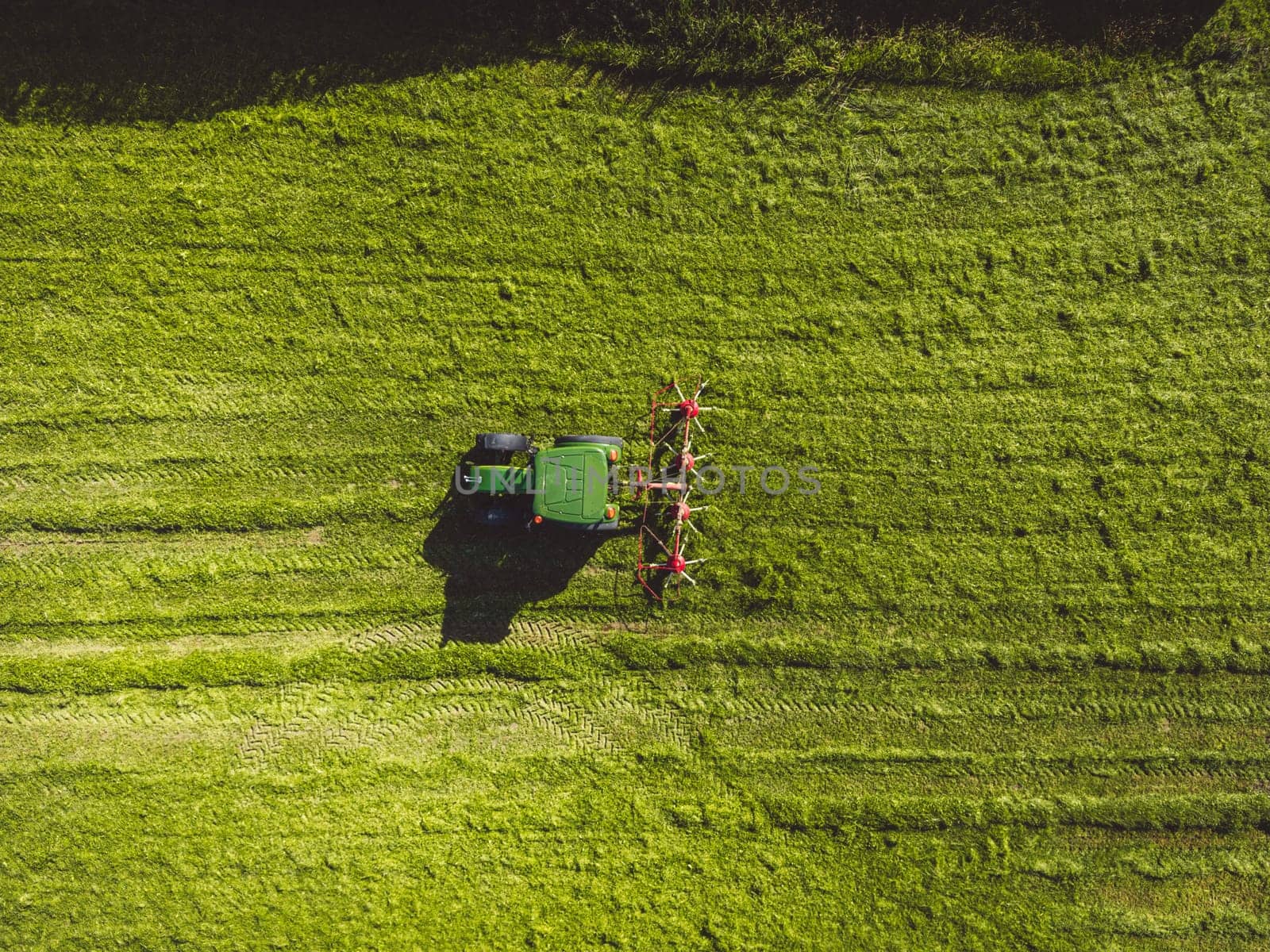 Top down view, directly above a tractor mowing a grass field by VisualProductions