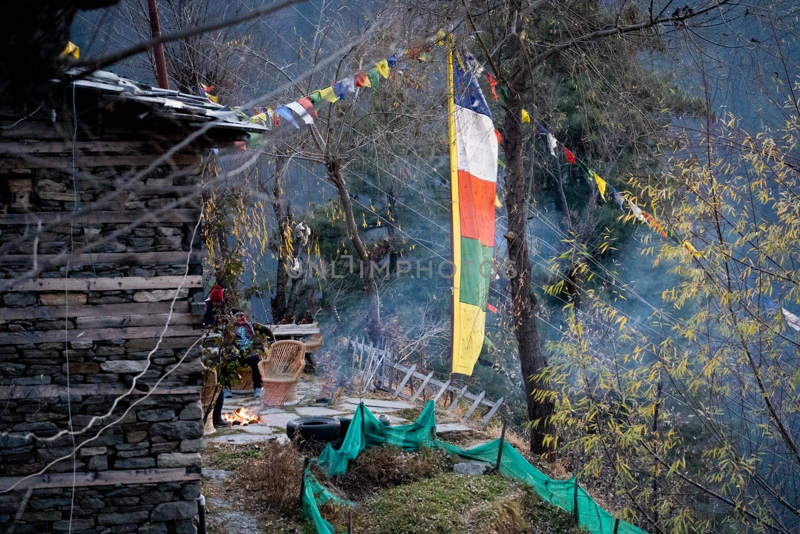 sacred religious multicolored prayer flags old and tattered torn outside wooden cabin in bhuddist prayer incantation common in hill stations in Himachal Pradesh by Shalinimathur