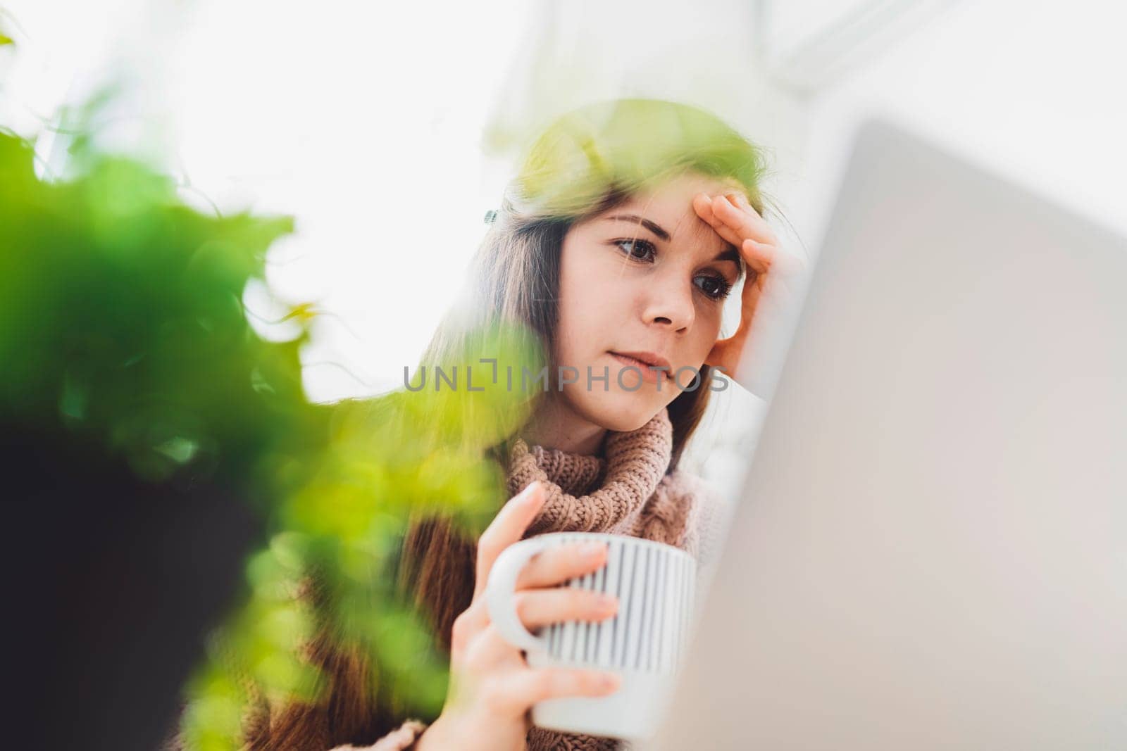Worried face of a woman working from home, behind on the deadlines by VisualProductions