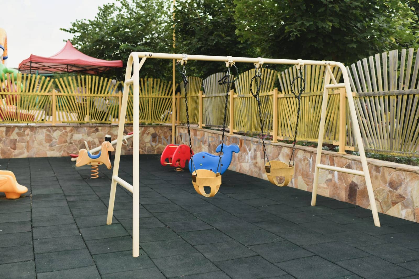Various Children's toys on the playground. Swing carousel in the park
