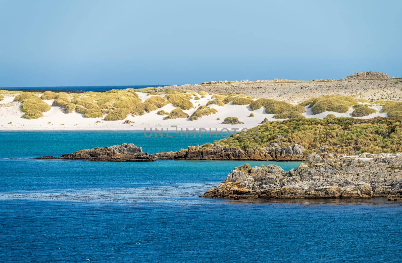 Sandy beaches and rocks when approaching the port of Stanley on the Falkland Islands from the ocean