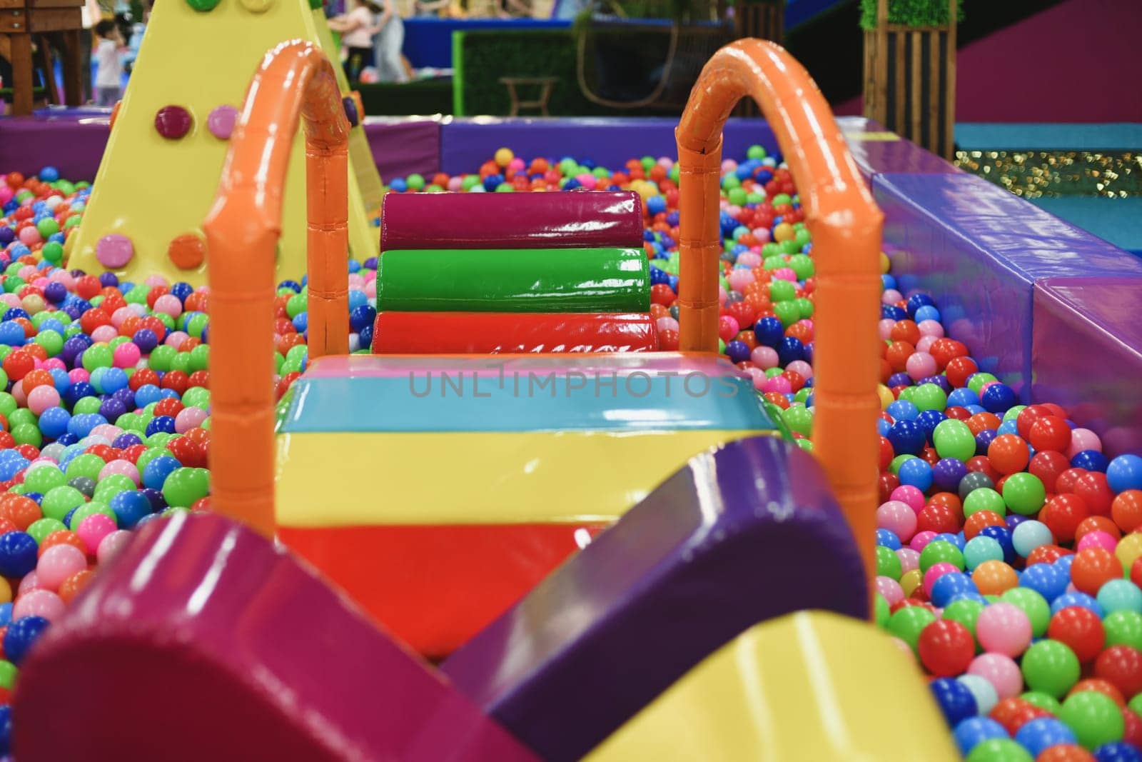 A dry paddling pool in playing centre with balls.