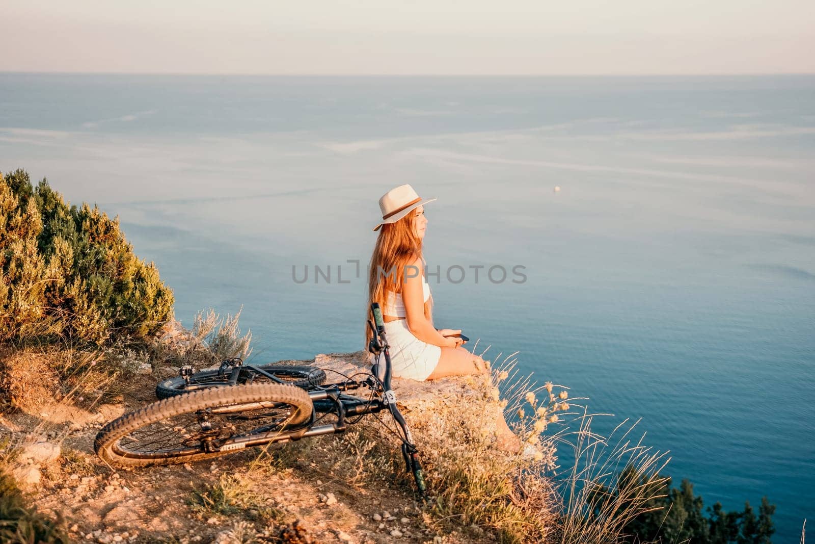 Woman travel sea. Young Happy woman in a long red dress posing on a beach near the sea on background of volcanic rocks, like in Iceland, sharing travel adventure journey