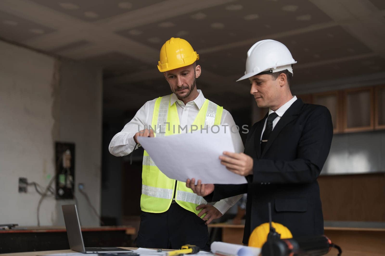 Diverse Team of Specialists Use Laptop on Construction Site. Real Estate Building Project with Engineer Investor and Businessman Checking Area, working on Civil Engineering, Discussing Strategy Plan..