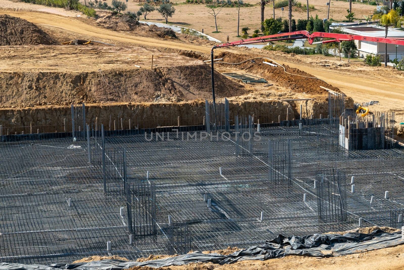 Concrete pump working on reinforced foundations at a large construction site