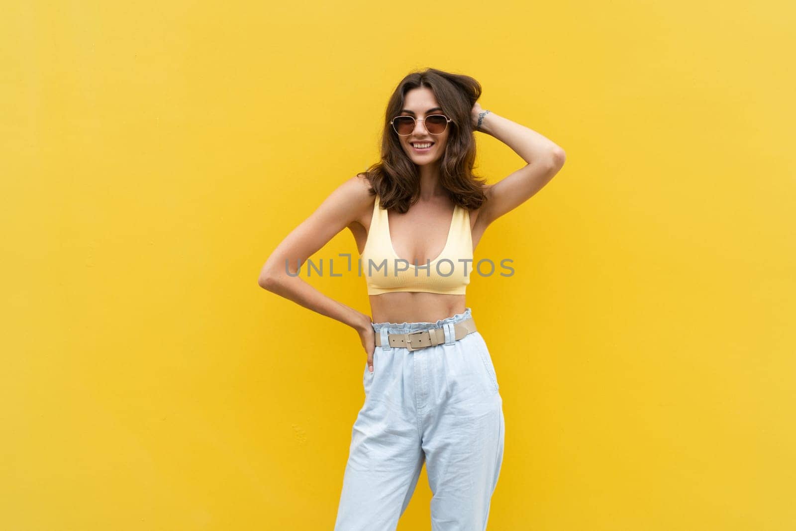 Young beautiful woman. Carefree woman posing in the street near yellow wall. Positive model outdoors in sunglasses. Happy and cheerful by kroshka_nastya