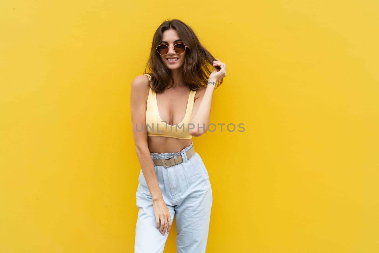 Young beautiful woman. Carefree woman posing in the street near yellow wall. Positive model outdoors in sunglasses. Happy and cheerful by kroshka_nastya