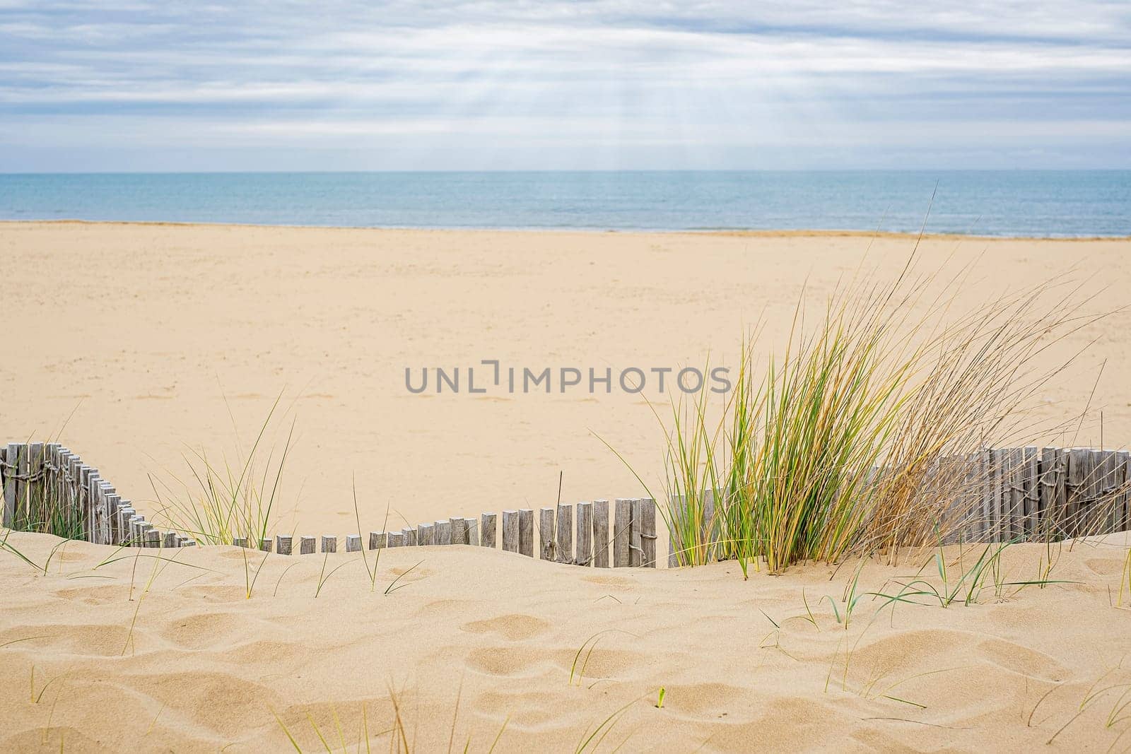 View of the deserted beach and the endless sea on a cloudy day.
