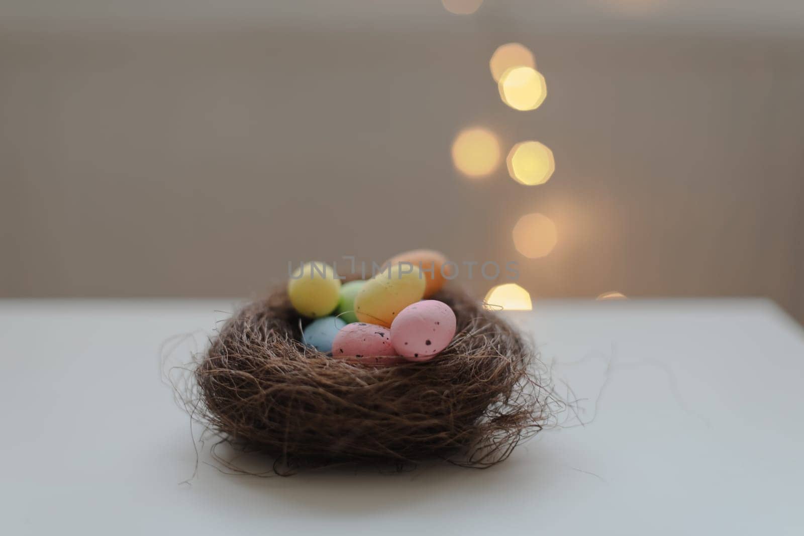 Colorful easter eggs in nest on pastel color background with space. High quality photo