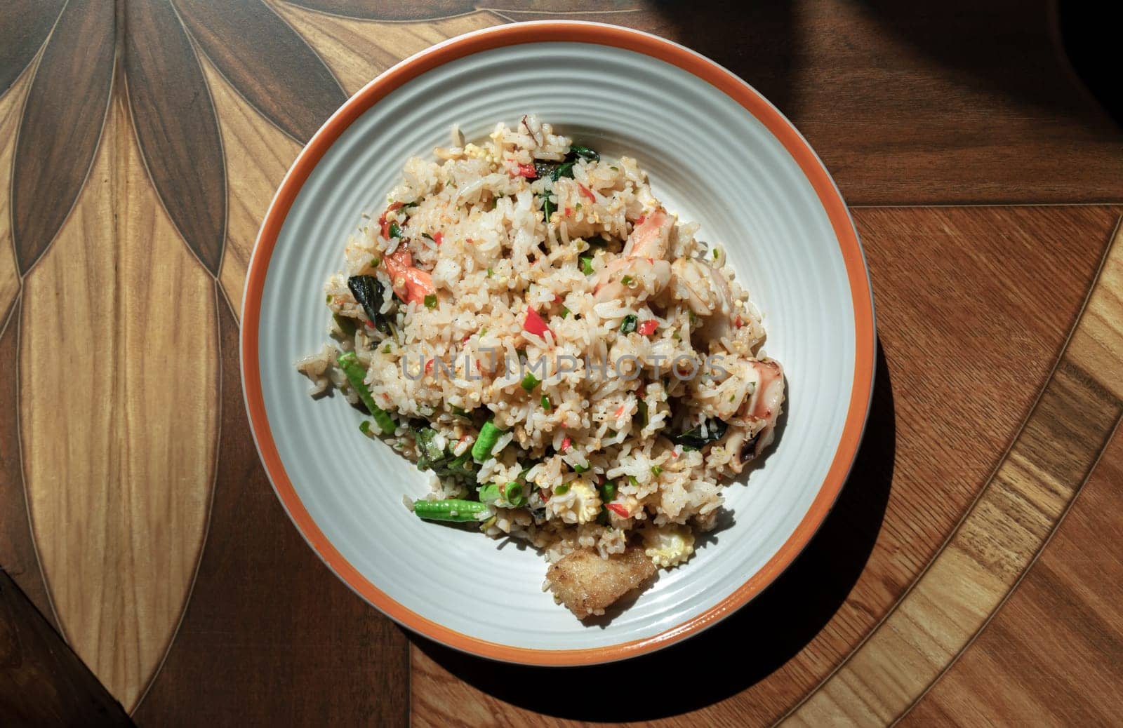 Homemade Holy Basil and Spicy Herb Fried Rice with Shrimps, Squid and Yardlong Bean. Thai Stir Fried Rice with Seafood and Holy Basil Leaf, Asian food style, Space for text, Top view, Selective focus.