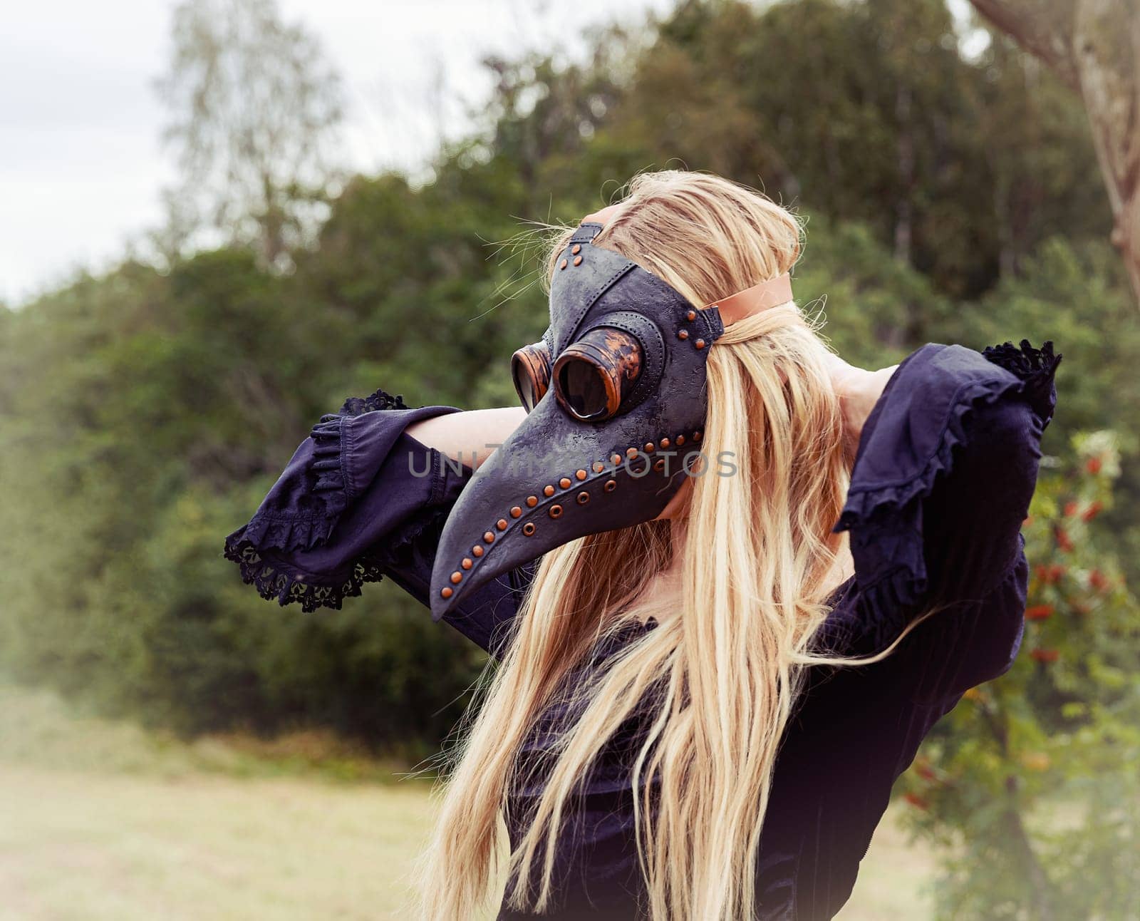 Intriguing portrait of woman in plague mask with forest background. by palinchak