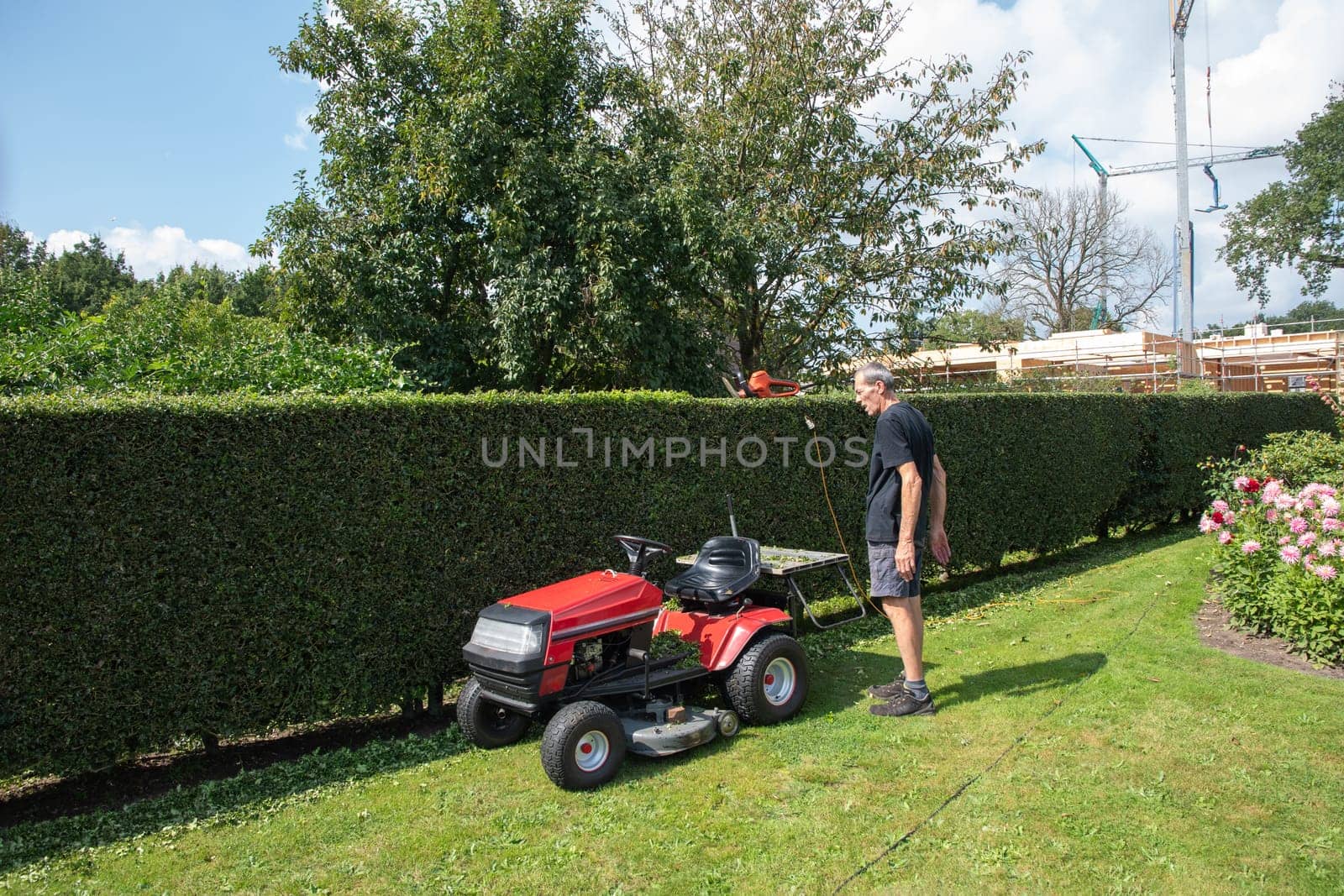 Male gardener using a lawn mowing tractor for cutting grass, professional gardening tools, High quality photo