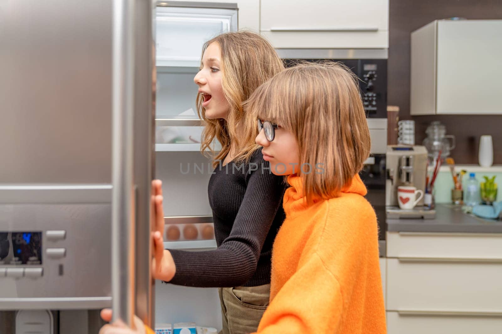 the children are watching the fridge in the kitchen by Edophoto