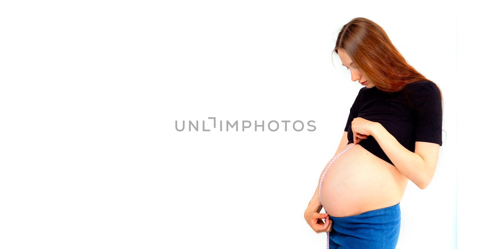 Pregnant woman measuring stomach with measuring tape. Banner with copy space