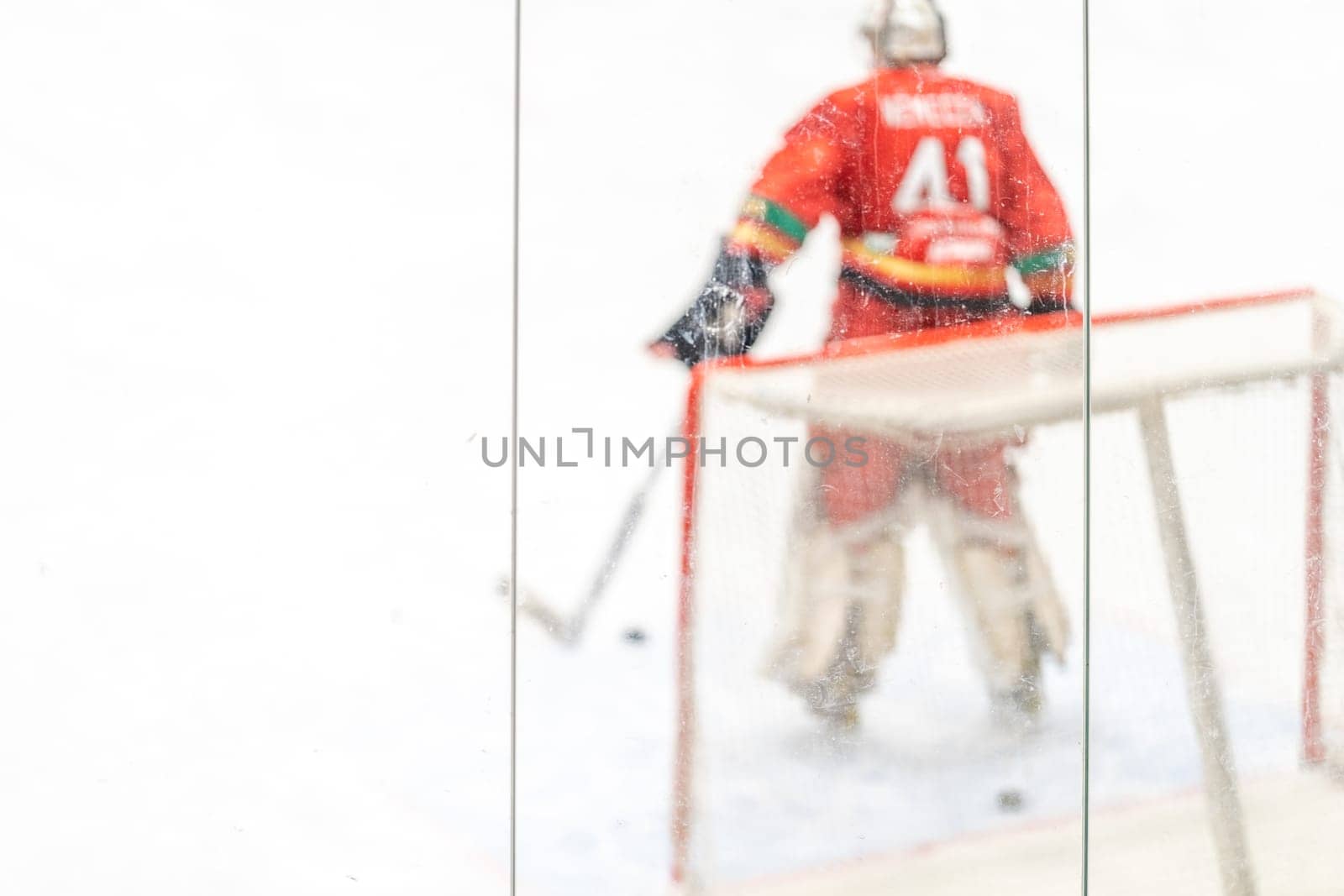 blurred view through protective safety glass. hockey goalie on the ice of the winter stadium. High quality photo