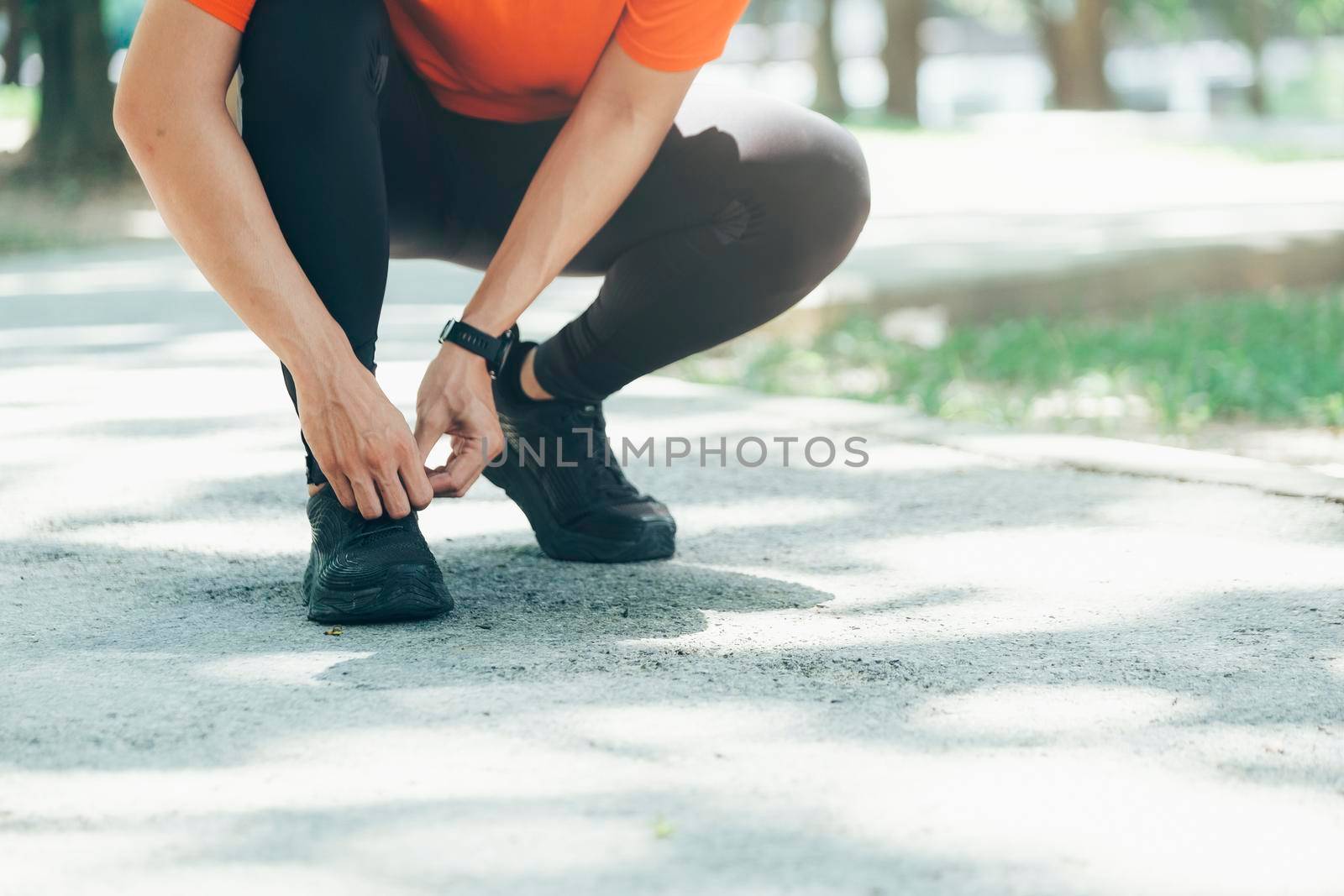 Young male jogger athlete training and doing workout outdoors in city.