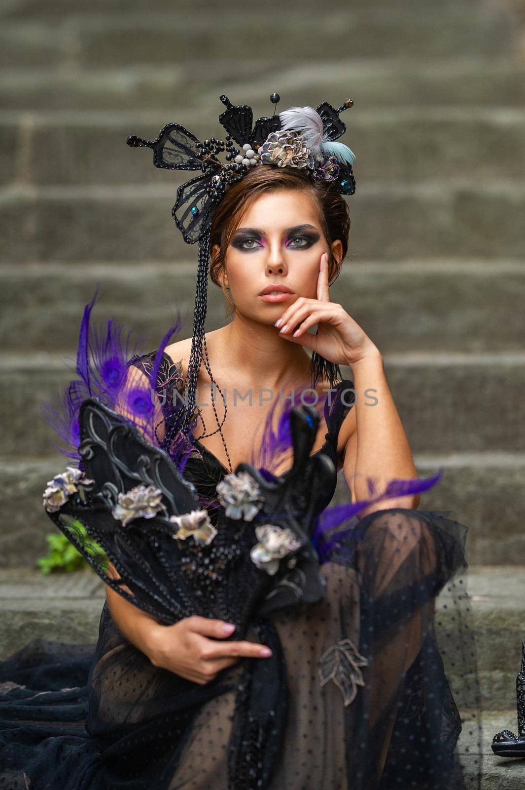 Beautiful stylish bride in a black dress sits on the stairs in Florence, Italy.