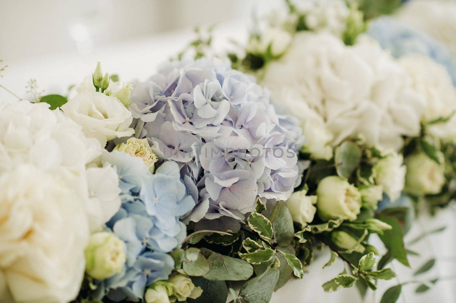 Wedding bride and groom table presidium decorated with a lot of flowers.