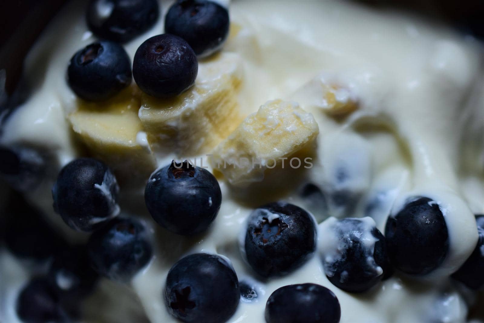 Close-up of blueberries and pieces of banana in yoghurt