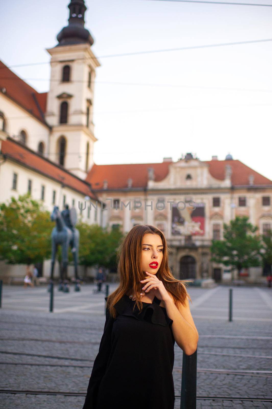 Stylish young girl in a black dress on the street of the city of BRNO in the morning.Czech.