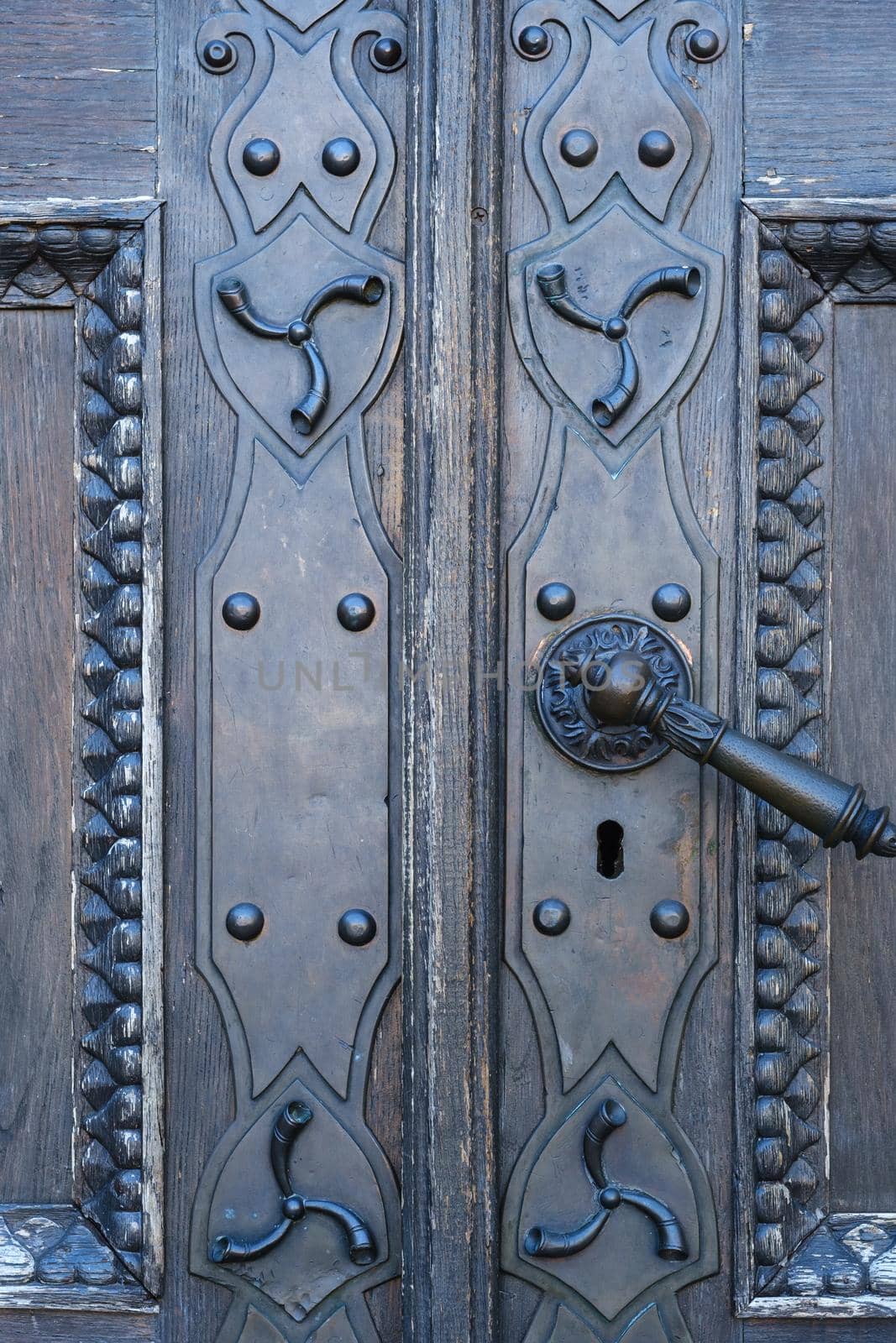 Old metal door handle on the old door.