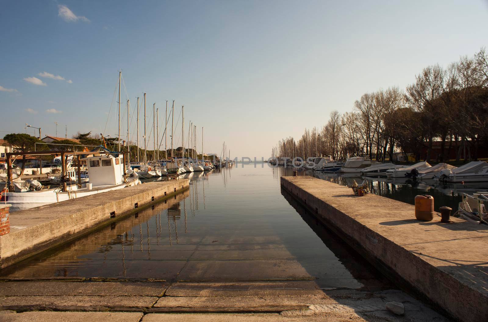 Dock in the Villaggio del Pescatore, Italy by bepsimage