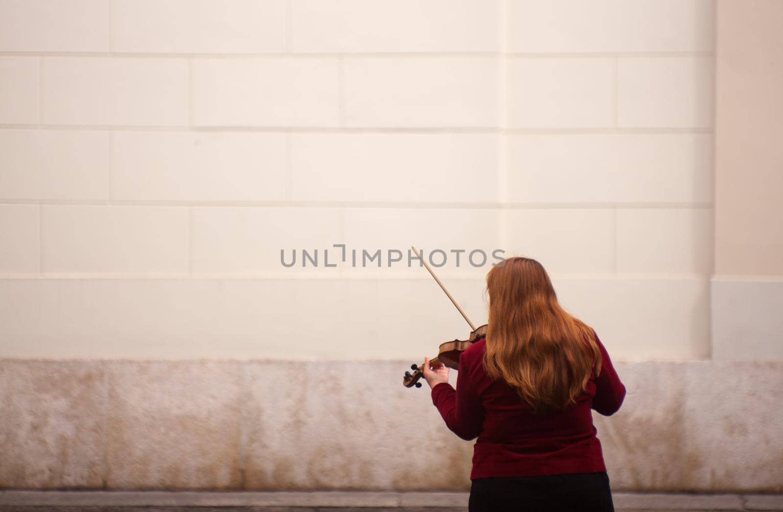 Female violinist playing in the street by bepsimage