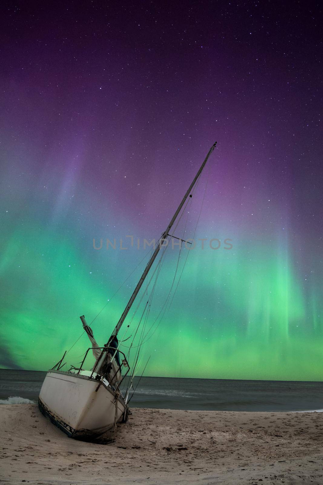 Aurora borealis over a shipwreck off the coast of Uttakleiv Beach by steffstarr