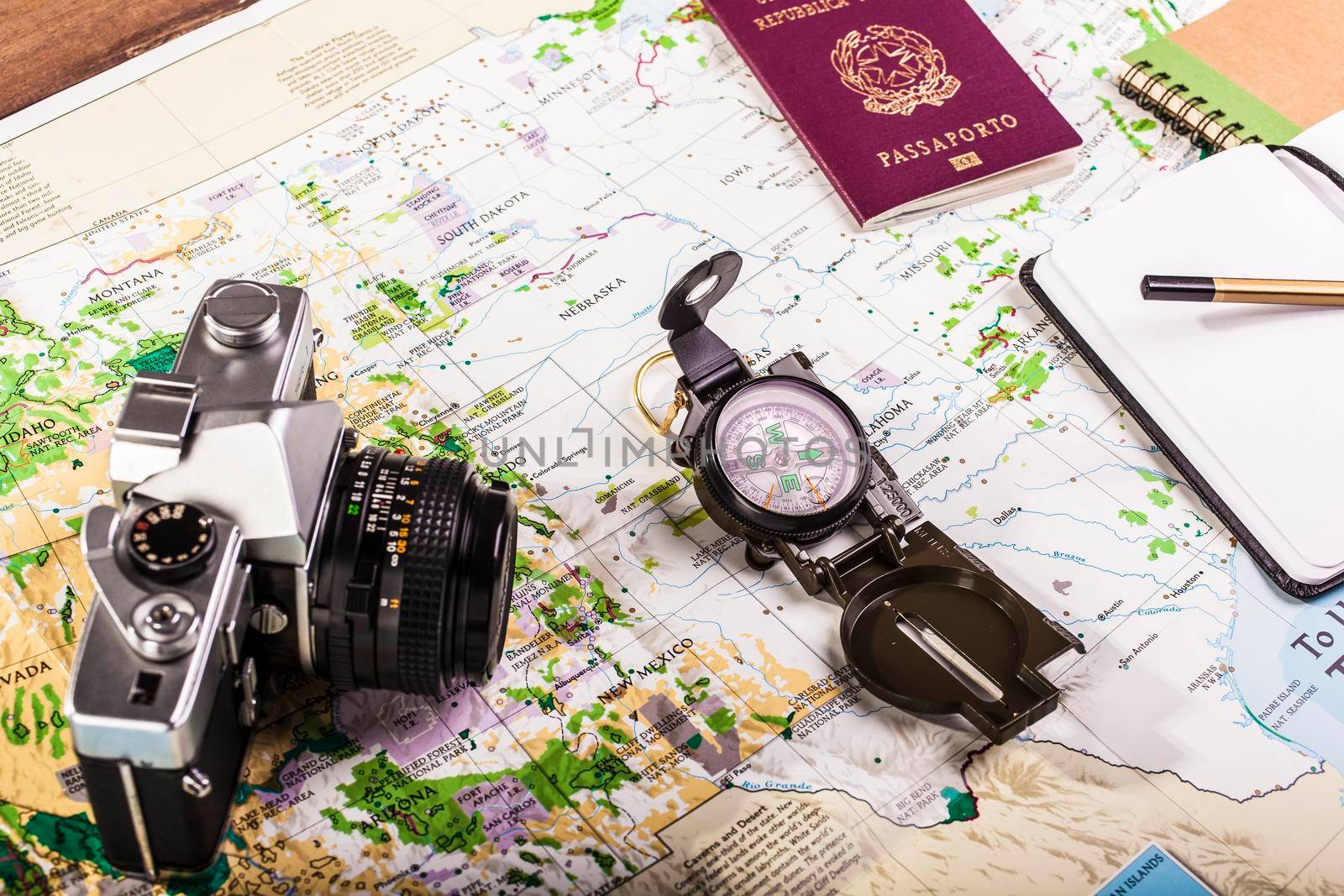 Travel planning. Compass, passport, photo camera and block notes on map