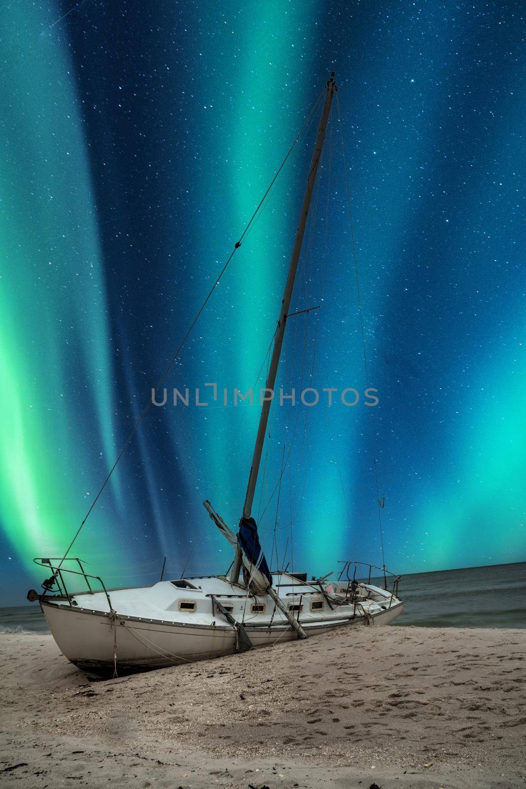 Aurora borealis over a shipwreck off the coast of Uttakleiv Beach in Norway