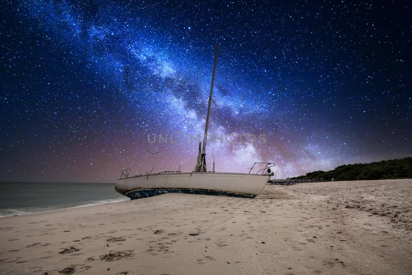 Milky way in the night sky over a shipwreck off the coast of Clam Pass by steffstarr