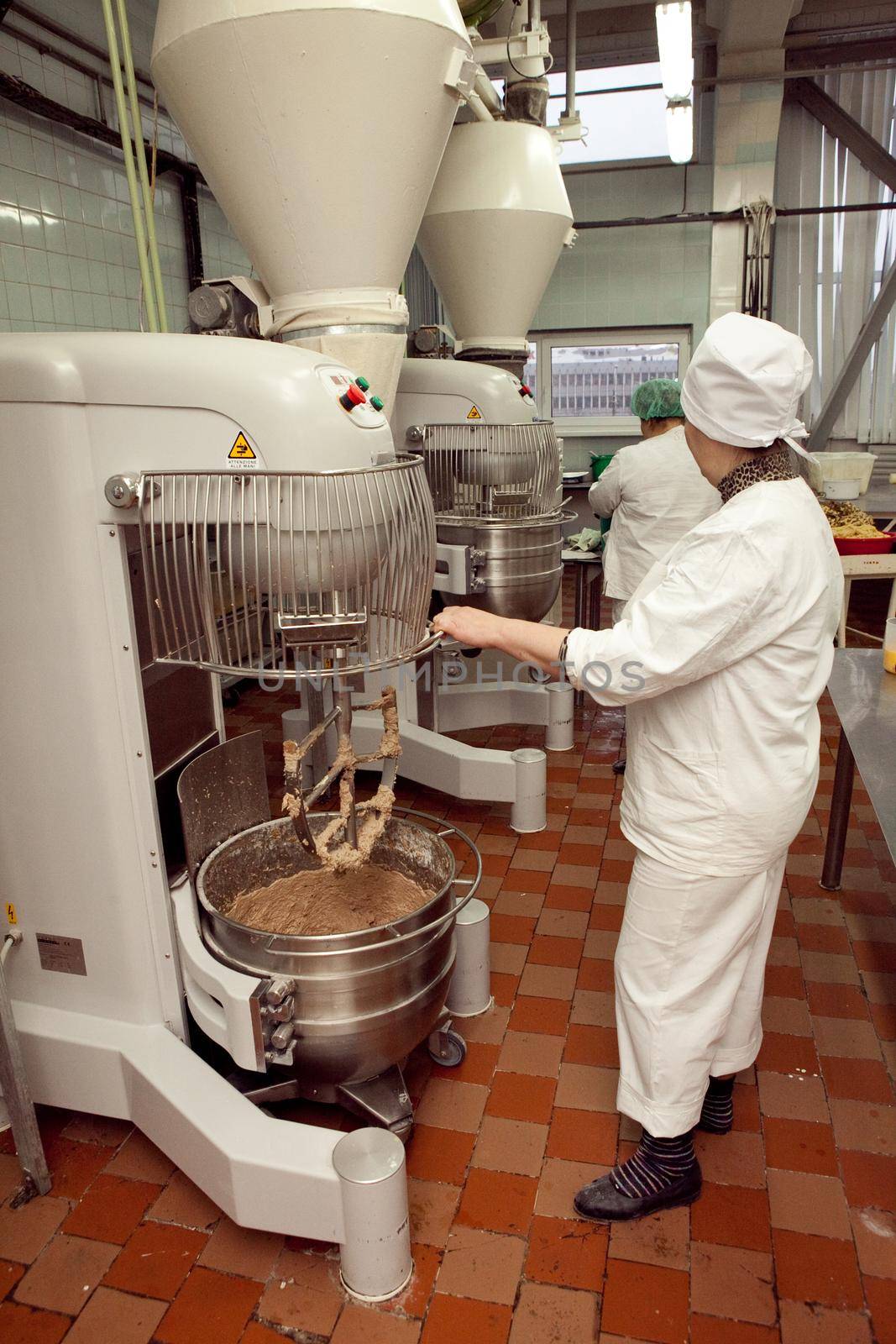 The process of making cookie dough in an industrial kneading machine at the factory.