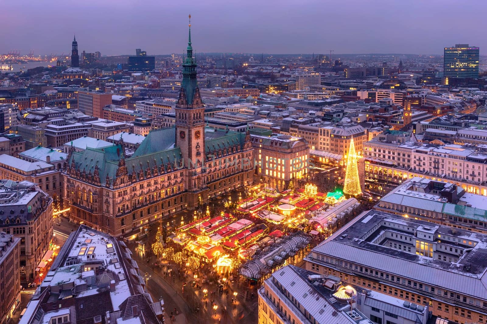 Aerial view of illuminated historic Christmas market on Rathausmarkt in downtown of Hamburg, Germany in the evening.