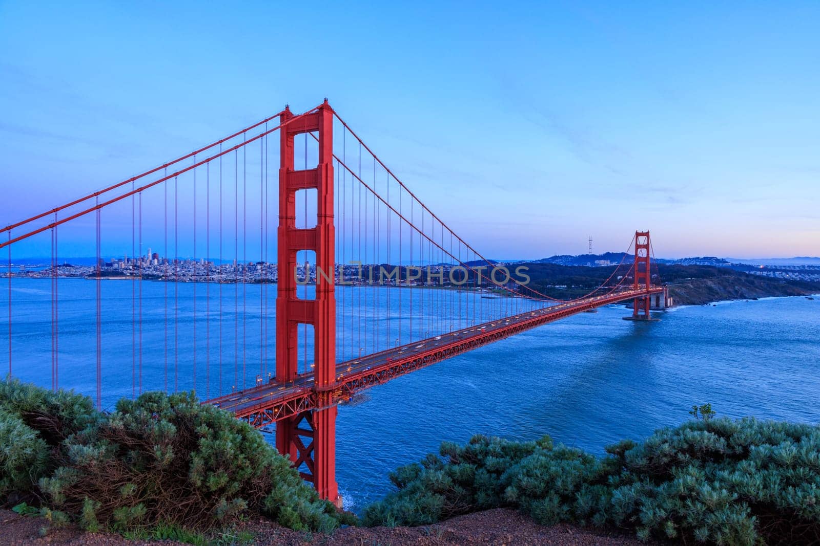 Iconic Golden Gate Bridge and San Francisco city on coast at sunset. High quality photo