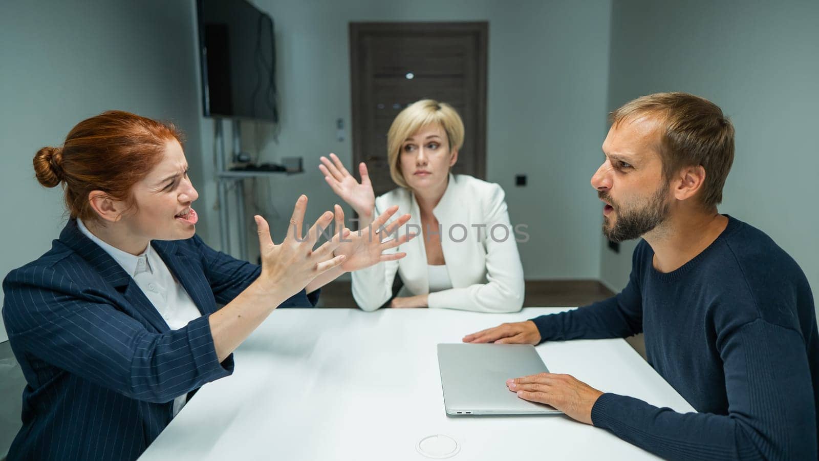 Blond, red-haired woman and bearded man in suits in the office. Business people are swearing during negotiations in the conference room. by mrwed54