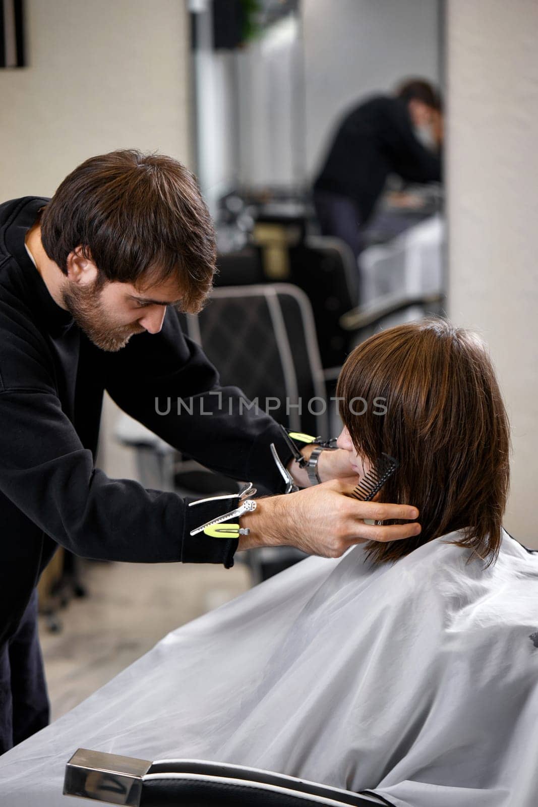 male hairdresser working with client at hair salon by erstudio