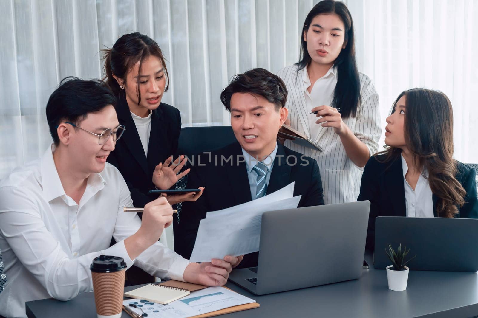 Harmony in office concept as business people analyzing dashboard paper together in workplace. Young colleagues give ideas at manager desk for discussion or strategy planning about project.