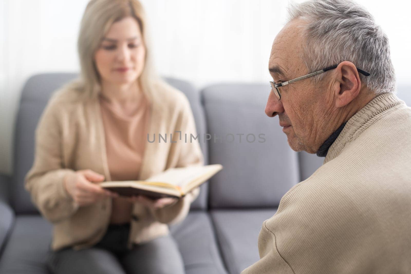 Close up anxious serious old man listening to female doctor at meeting in hospital, therapist physician consulting mature patient about disease, treatment, elderly generation healthcare concept by Andelov13