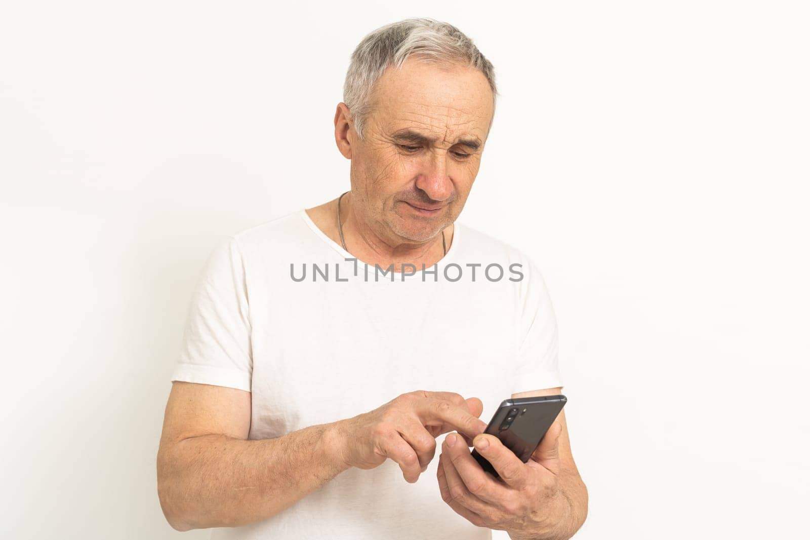 older mature retired man feeling upset desperate talking on the phone having problems debt, stressed sad middle aged male depressed by hearing bad news during mobile conversation at home by Andelov13