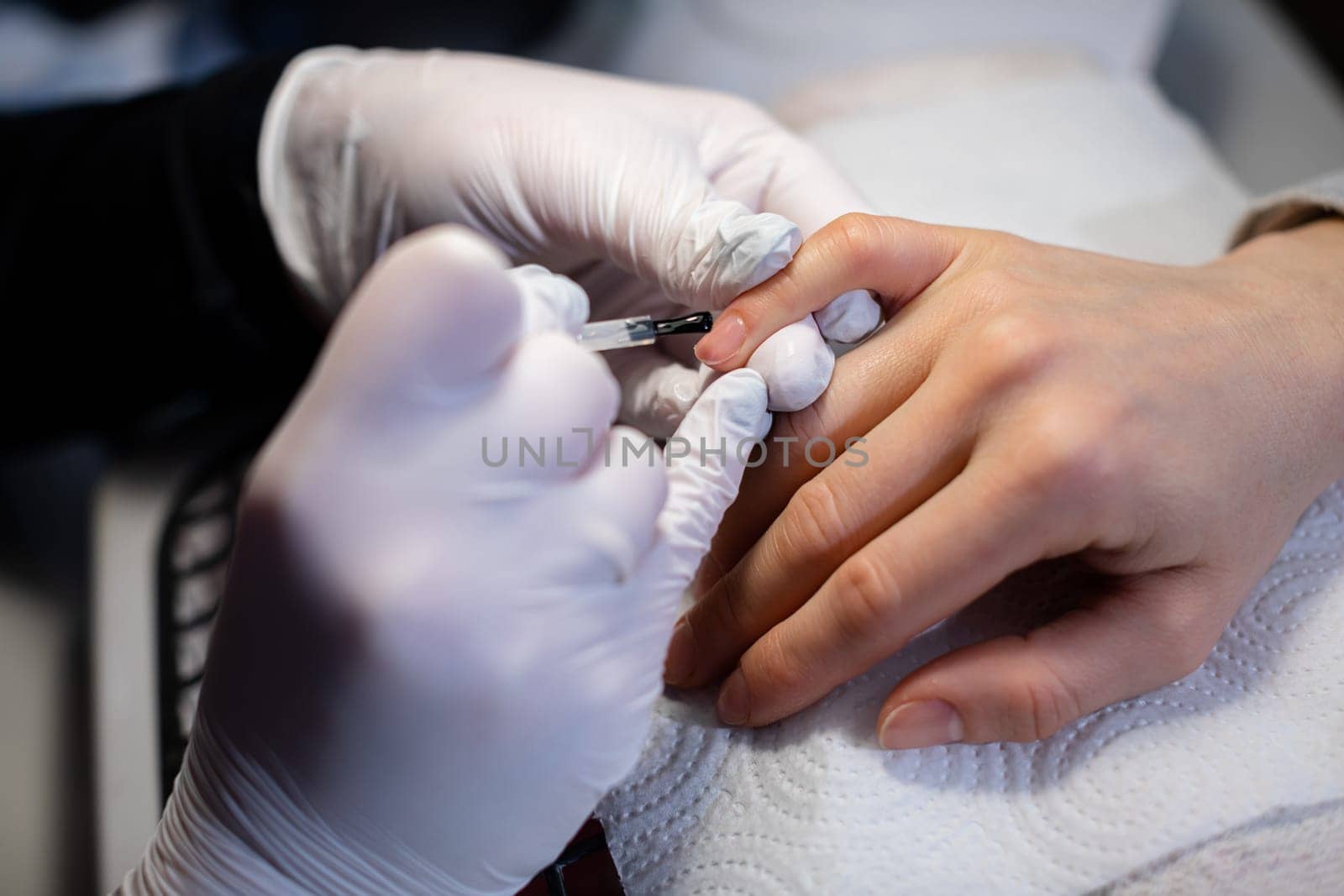 Work as a beautician and manicurist. Performing hybrid manicure on natural nail plate. Applying hybrid polish on the natural nail plate.