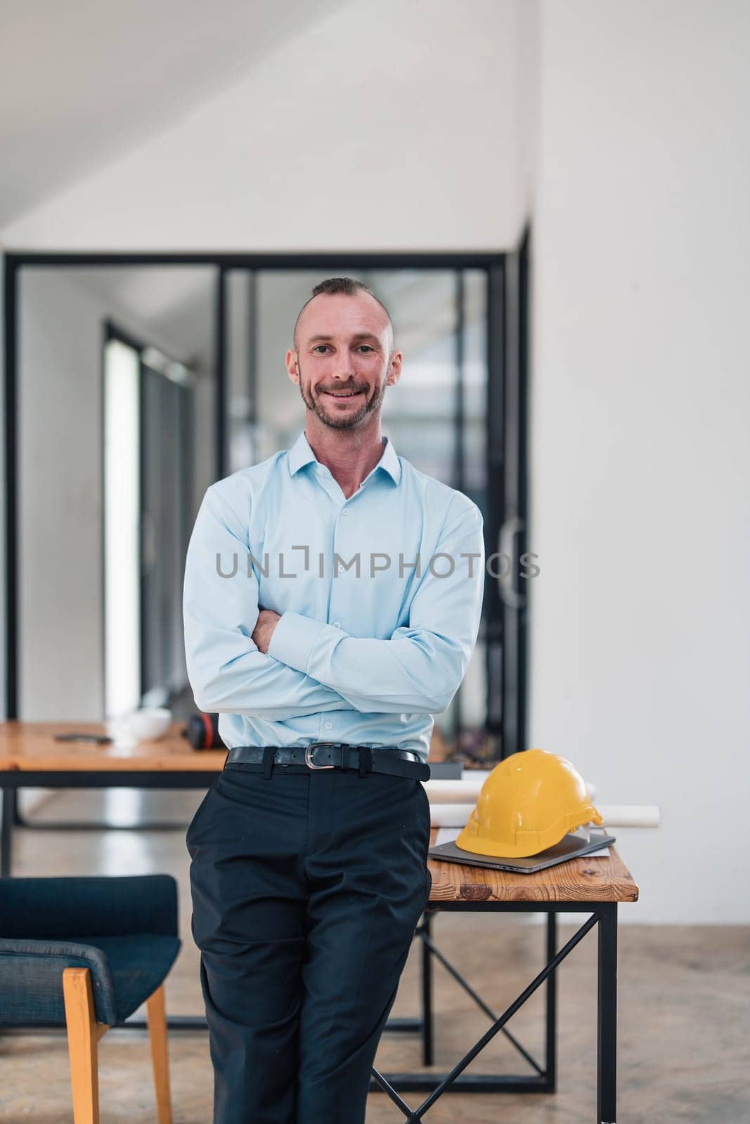 Portrait, Successful and confident Caucasian male engineer or architect stands with arms crossed in the engineer's office...