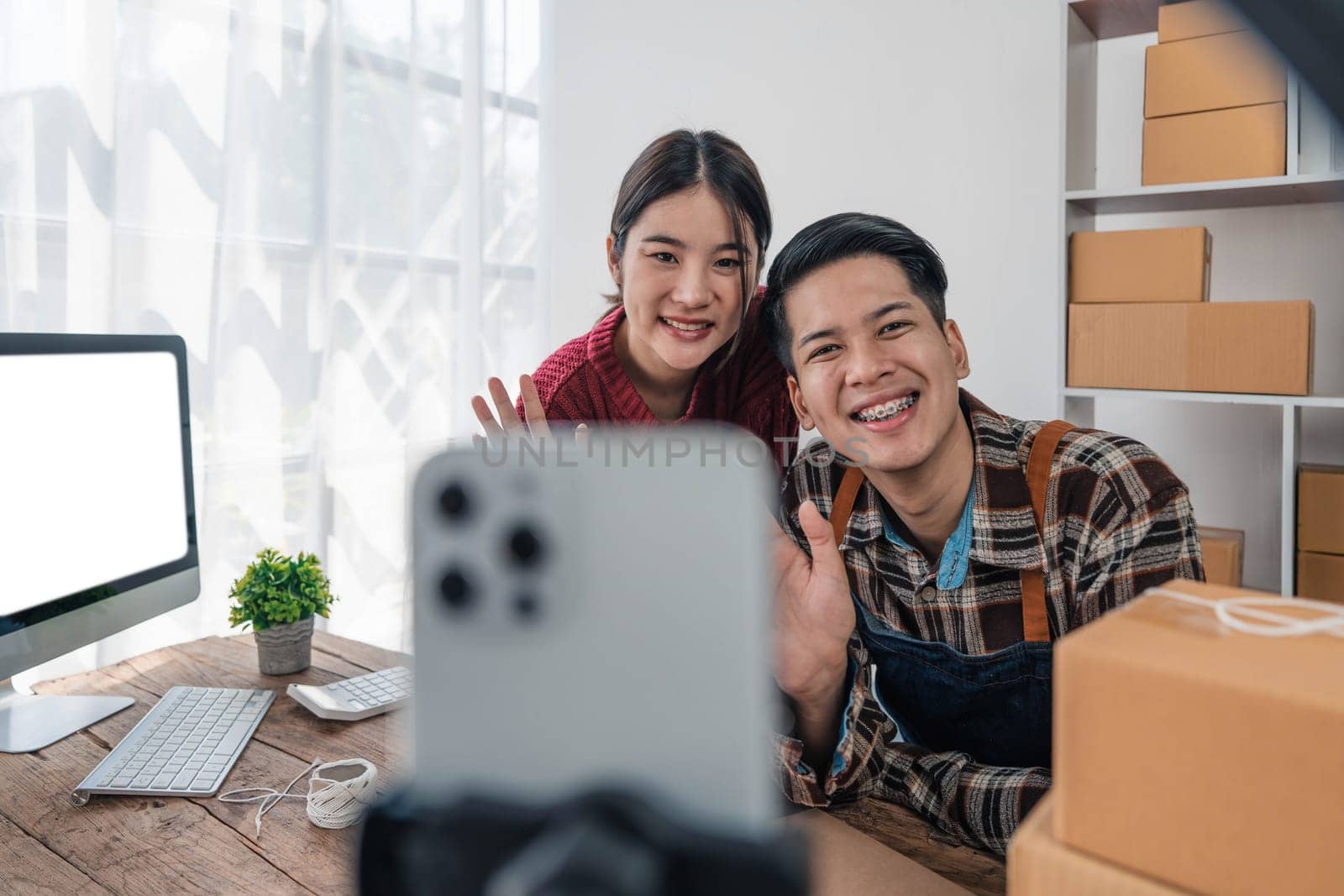 Young asian people couple Male and female small business owner checking online orders and packing the product together