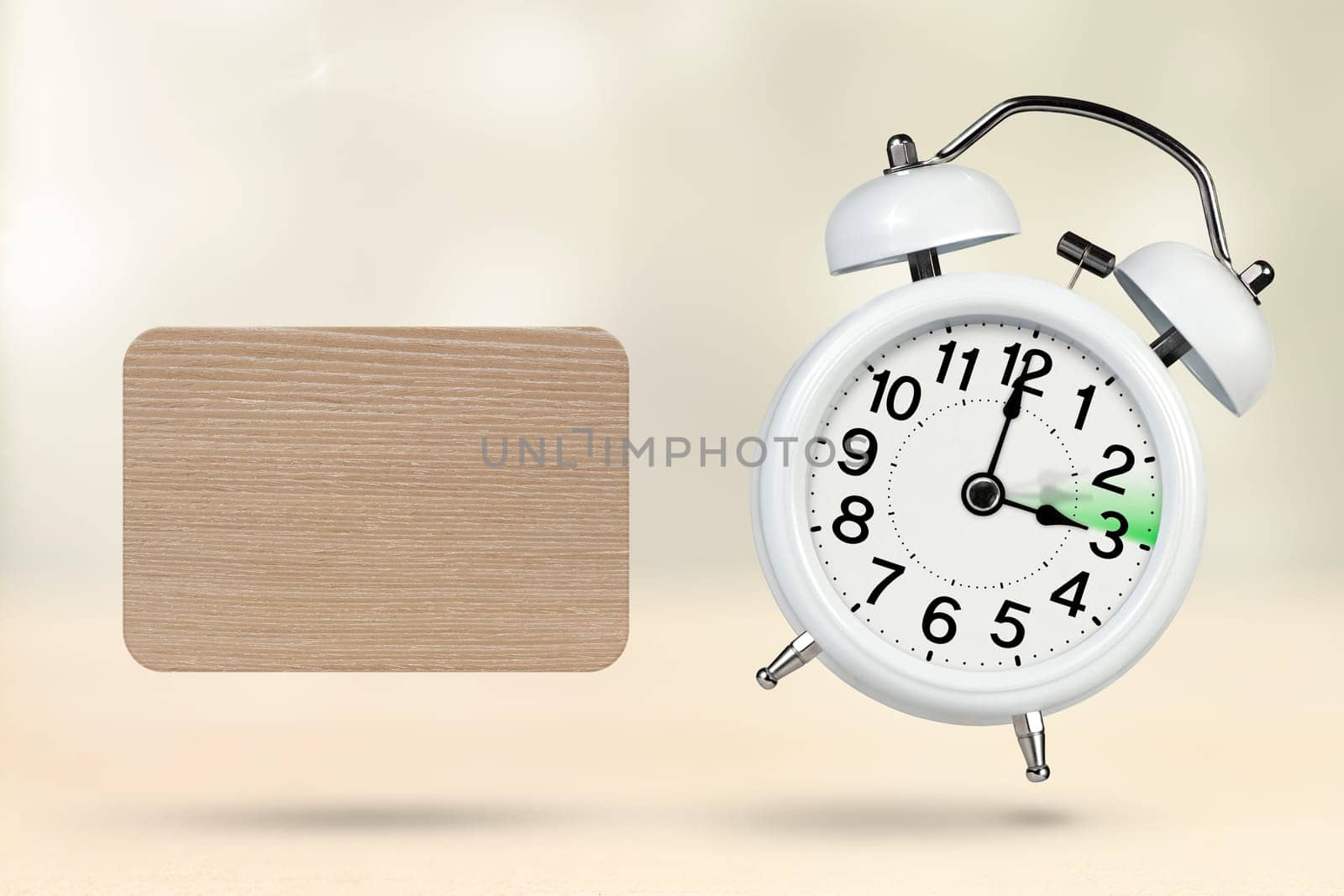 Change time. Summer time concept, on a wooden background. A white alarm clock with a minute hand indicates that the time has been moved forward an hour with copy space