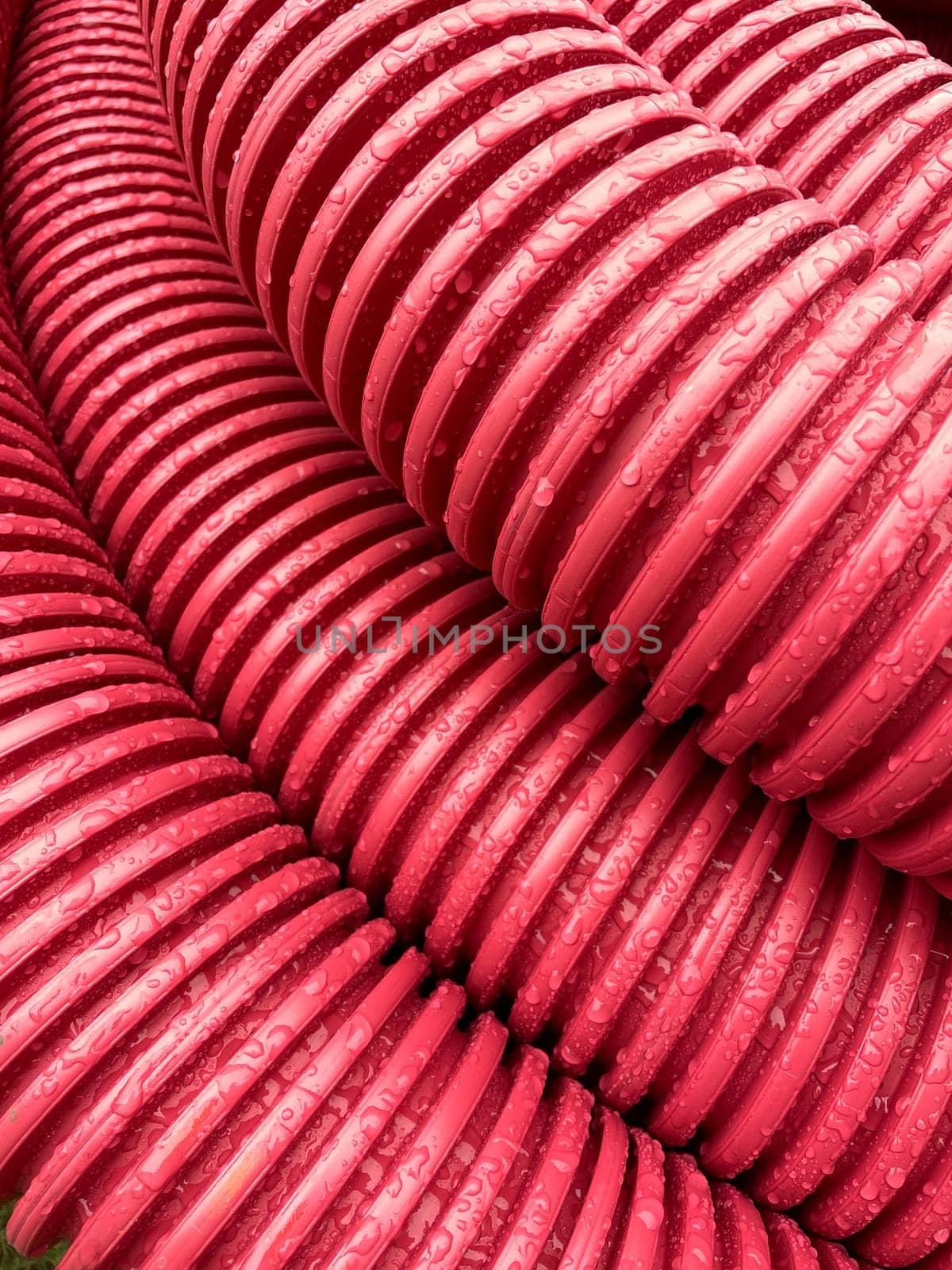pile of plastic pipes wet from the rain, corrugated burgundy pipes, magenta abstract texture background, color of the year, High quality photo
